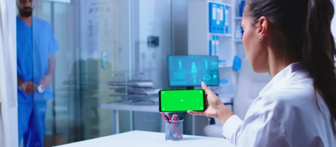 Doctor checking patient results on smartphone with green screen in hospital cabinet. Nurse in blue medical uniform closes glass door. Healthcare specialist in hospital cabinet using smartphone with mockup. SSUCv3H4sIAAAAAAAACpRVyY7UMBC9I/EPo5yx8L7wBVy4cUMcHNvpjkjiVuKwaDT/TmVx2hlmQEh9aFc9V5Vf1as8vn3z8FDVdmpd9eHhcTnBue26eUqjTW0cwIzf7fYxDD6MpSX4NsWxtV1prG1y18H2AYzD3HWL+Wl1VlOyaZ7CVCSbrnNKYZxSdN/AzHIU62Md/rD6cItTm27XmOJUOm5x8OKEHIPtp9SuZRxWF7s4j3X8CUZypOps/6tE9XG6pzhgfVwICV3ow5AWD1VH9vZnsmUEQtnYLIbi8c6mcAG2Ts/P3H/Zzg/ZsVVrE7iqj8F26ersGN5/AsYd0L3n2Ric6wX1qZ1c6Do7hDhPVfZvuV8J/DlAo4CRy6//CLj9+XqQdwmDW9h7fCreOgJNdmv0/rKKKue9EgQRwSziAROkDa4R80IwLzkx0MBjhqhQoSEOOYoBTEJAhliMqGOaUWEb4t0BZlgwGhqGQiMAXBOPakrh6DFlwQrCTX2ANZaGKuoQFS4gLusaWR8wcnVNiKeiCUYeYMotswFL1GhhEDfaIiMxhsIVDsQ446xdmdnoqL79gFHu1/7uRNjZt7Ho9/cI7Vsnt2DrNrauHS7FtZiuq9LyNRfnIY0LzdVRXBfjzdbdMt8NxAzZfrXTBHCf7eUIgq5jX+QZYlqbtEetPMzociSMciYo44oLojmlvCoVfG0hzlpOLnC+dRF4XJIeg/Zc20QYLTXhVBzTdpb5DlDM3AHPFZ8xPO+bQvyHjxb3yz3wEuC0ErI/C7nYDoeP333nRZEBeS28tDN2kDZFhrw9Nh8logiQF8nu44ZsrqzrRax9CyyfmX92TTP5V8rPgBfbRrVif2WVGqr/1TZqpHjt3Yxg8VpLGT094N4Rg7mRVOycnL40UHzry1WbOYHi7SVODjLAKyjGGhPM2KGrEz8Vg4ZzJczdP53pqYjGHH5QzQE50VMRw5XSjO0aeoGdimPBASLxAcnkVFIxQrG6B8/UgEhhIIQi97iZmSoIEaipG+S1IogzJZFtMENSeUJgsXLQ6rq4drraZXxA/UZ52XhElIR1FxqHDDUeae2kgyKkZQJuPf0GAAD//wMAysJnazcIAAA=